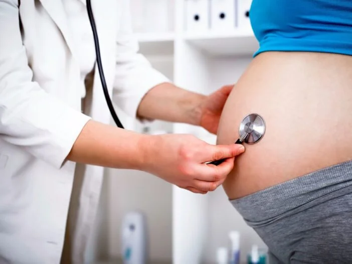 Médica examina a barriga de uma gestante com o estetoscópio
